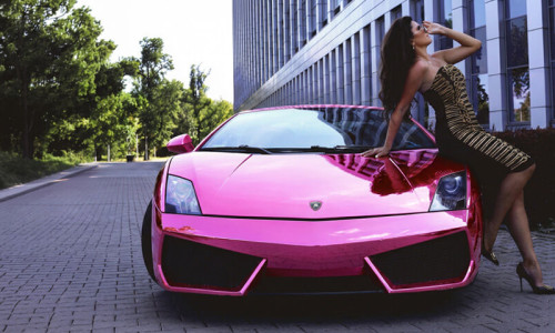 Kobieta pozująca na różowym Lamborghini Gallardo